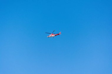 Mavi arka planda kızıl haçlı bir tıbbi helikopter.
