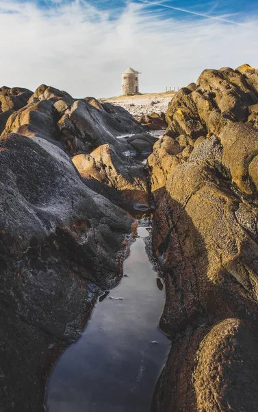 Uzaktaki Bir Değirmenle Kayalar Arasındaki Dar Bir Derenin Dikey Görüntüsü — Stok fotoğraf