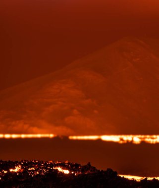 Volkandaki lavların karanlık arka plandaki manzarası.