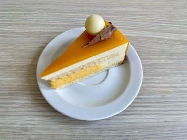 Lezzetli bir tutku meyveli pasta ve beyaz bir tabakta sütlü çikolata süslemesi.