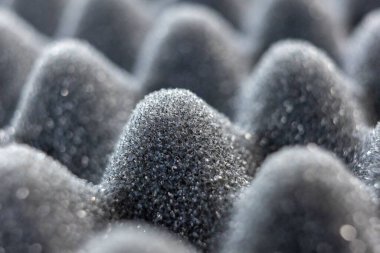 Bulanık arkaplanı olan gri ses izolasyon köpük dokusunun seçici odağı