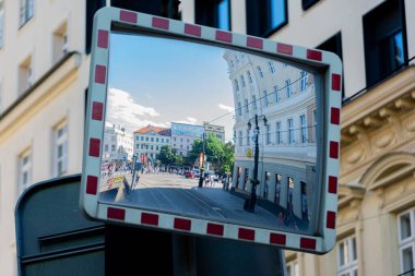 Bratislava, Slovakya 'daki binaların olduğu caddenin yansıması olan dışbükey bir trafik aynasına yakın plan.