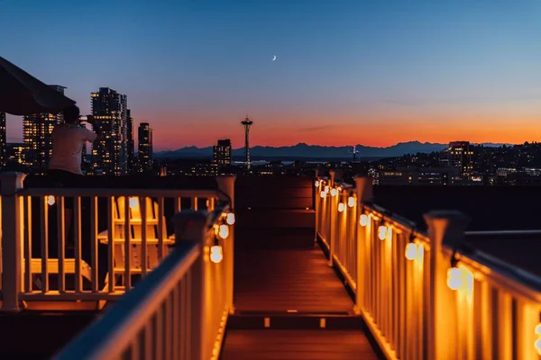 男子与西雅图天际线从国会山顶楼拍摄落日的电话照片 — 图库照片