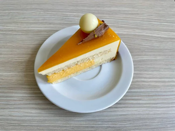 Lezzetli bir tutku meyveli pasta ve beyaz bir tabakta sütlü çikolata süslemesi.