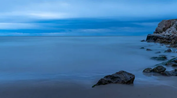 穏やかな曇った海の岩 長い露出 — ストック写真