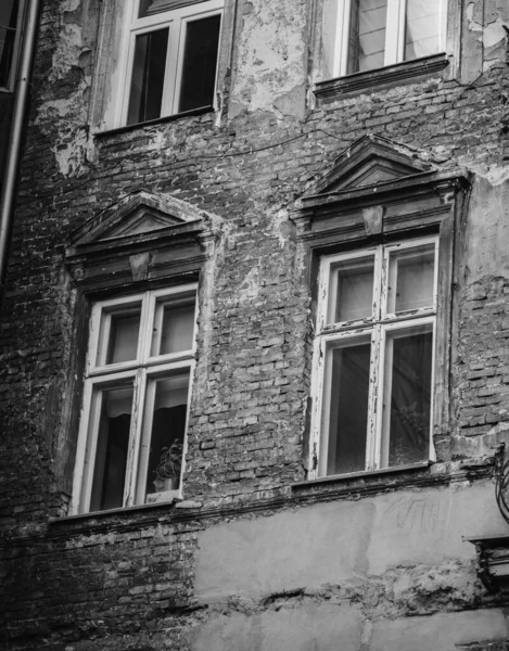 古い窓のある古代の風化した建物のグレースケール — ストック写真