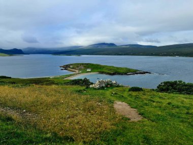 İrlanda, Connemara 'daki Derryclare Gölü. Doğa manzarası. Su, dağlar ve mavi bulutlu gökyüzü ile güzel bir manzara. Popüler turizm simgesi