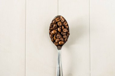 Metalik kaşık üzerinde kahve çekirdekleri, üst görünüm kopyalama alanı veya metin alanı