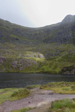 Güzel bir nehir manzarası ve açık gökyüzünün altındaki dağlar.