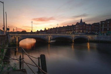Cork 'un simgesi St Patrick Köprüsü' nde şehir manzaralı bir gün batımı.