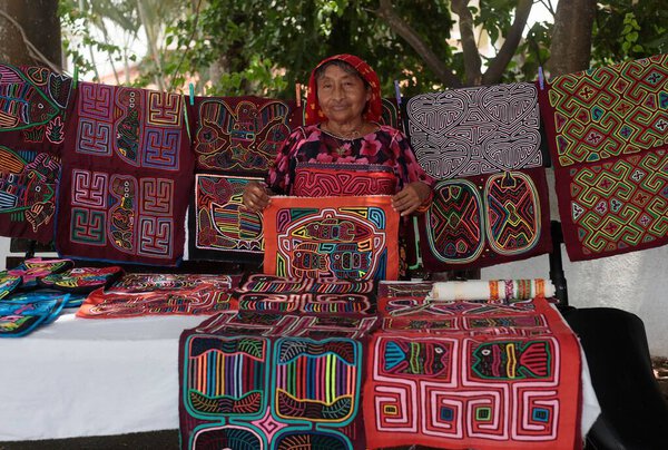 A closeup of a South East Asian woman showing a colorful mola fabric