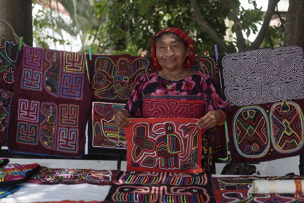 A closeup of a South East Asian woman showing a colorful mola fabric
