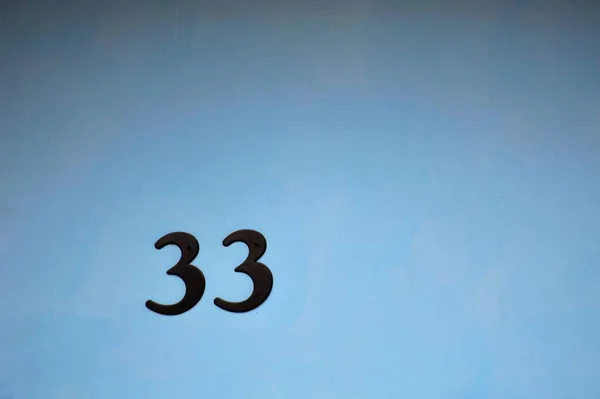 ライトブルーの背景に隔離された番号プレート33の閉鎖 — ストック写真