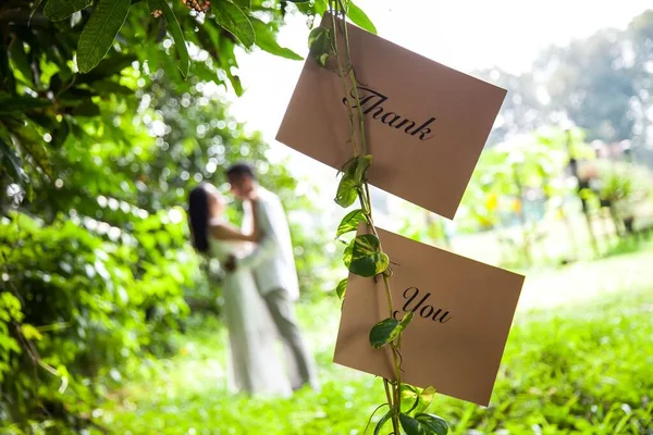 ありがとうの閉鎖ショット新婚旅行の背景に緑の木の枝にぶら下がっている結婚式のカップルのためのカードメッセージ — ストック写真