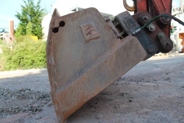 Yerdeki paslı bir kazma kovasına yakın çekim.