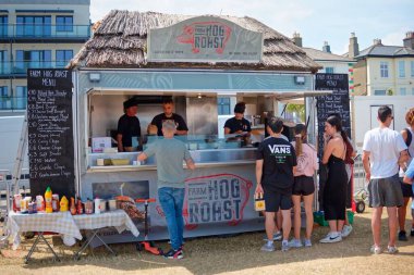 Bray, İrlanda 'daki Plaj BBBQ Festivali' nde yemek standı ve müşteriler bekliyor.