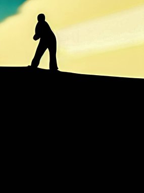 Tepede koyu renk arka planlı siyah bir adam silueti
