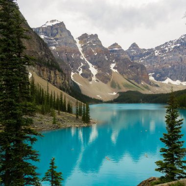 Kanada Alberta 'da dağlarla çevrili Moraine Gölü' nün güzel bir görüntüsü.