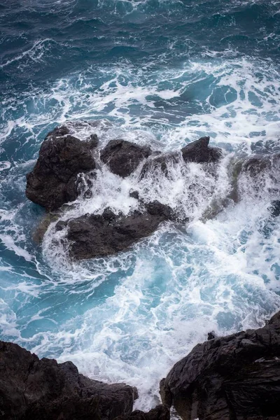 Pionowe Ujęcie Pięknych Fal Morskich Uderzających Skały Plaży — Zdjęcie stockowe