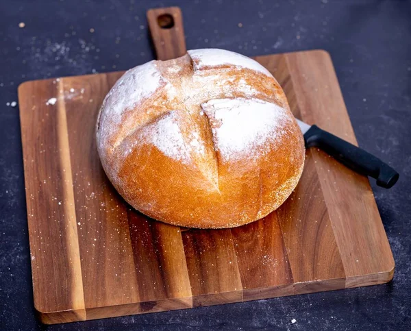 用刀在木制切菜板上的高角新鲜面包 — 图库照片