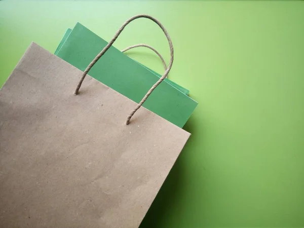 Paper shopping bag with books on green background