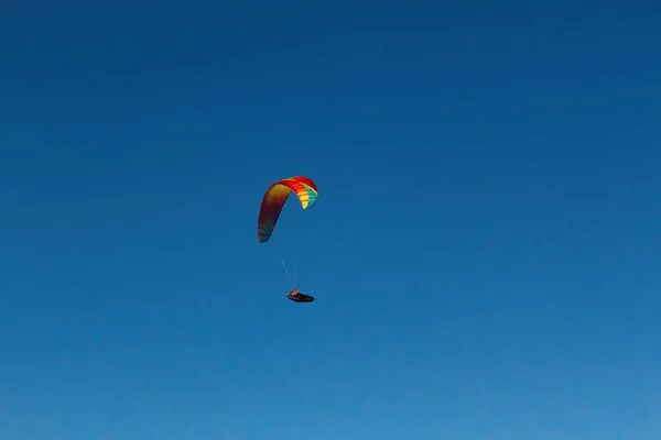 Niski Kąt Ujęcia Paralotniarza Lecącego Bezchmurnym Błękitnym Niebie — Zdjęcie stockowe
