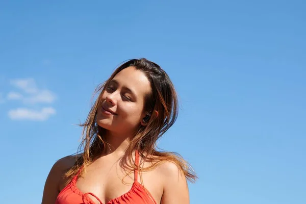 夏天的时候 一个年轻的女人在蓝天的背景下 闭着眼睛享受着休息 — 图库照片