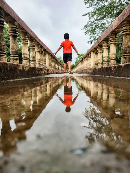 Boy Standing Corridor Picture Reflecting Grounded Water — Stock Photo, Image