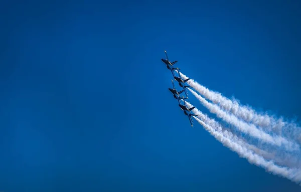 在蓝天的背景上 四架蓝角喷气式喷气式飞机的美丽镜头伴随着浓烟尾随着喷气式飞机 — 图库照片