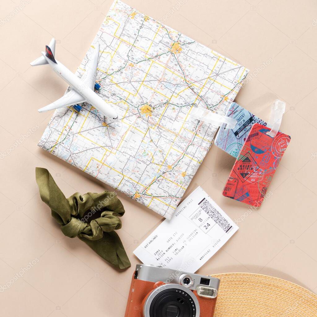 Travel flat lay with map, luggage tags, and toy plane