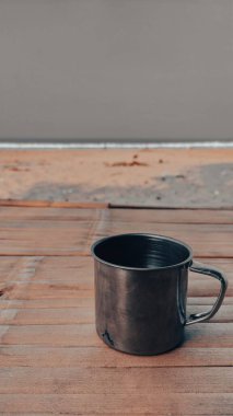 Ahşap bir güvertede paslanmaz bir kupanın yakın çekimi.