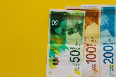İsrail banknotları. Yüz, elli ve iki yüz şekel. Kopya alanı olan sarı arkaplan.
