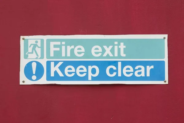 Kırmızı Arkaplanda Yangın Çıkışı Temiz Yazan Bir Uyarı Uyarısına Yakın — Stok fotoğraf