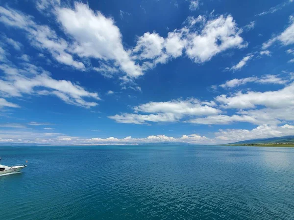 明亮的蓝云笼罩在明亮的蓝色平静的大海之上 — 图库照片
