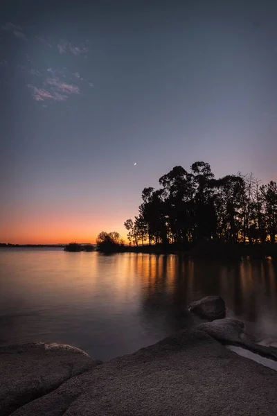 Eine Vertikale Aufnahme Einer Wasserlandschaft Bei Sonnenuntergang Mit Bäumen Und — Stockfoto