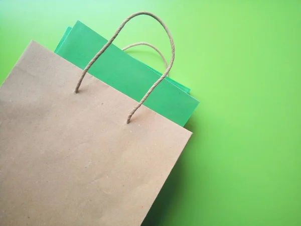 緑の背景に本のある紙のショッピングバッグ — ストック写真