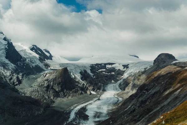Üzerinde Kar Olan Kayalık Bir Dağın Tepesi Gökyüzünde Büyük Bir — Stok fotoğraf