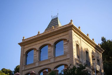 Barcelona, İspanya 'da Park Guell' de bir binanın dikey görüntüsü. Pencerelerinde gökyüzünün yansıması var.