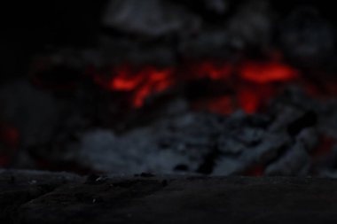 Arkaplanda şömine alevi olan koyu taş ürün ön plan görüntüsü
