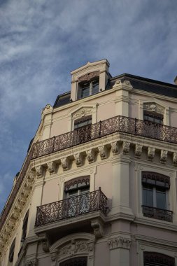 Arka planda mavi bir gökyüzü olan güzel, modern bir binanın ön yüzü, dikey bir çekim.