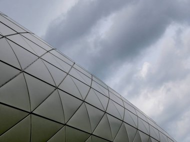 Modern mimari dramatik bulutlarla gri üçgen cephe