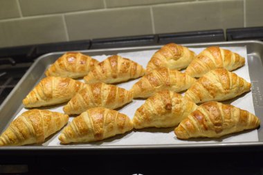 Bir tepsi kruvasan gri fayanslı arka planda