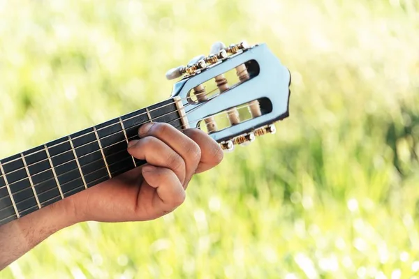 用绿色背景的西班牙吉他弹奏的年轻吉他手 — 图库照片