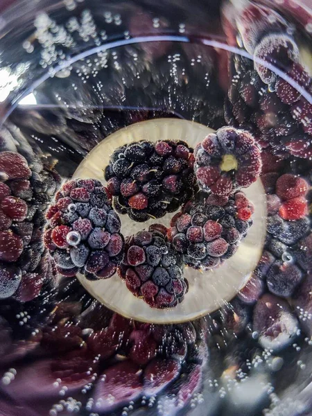 一杯水中漂浮着的黑莓的特写 — 图库照片
