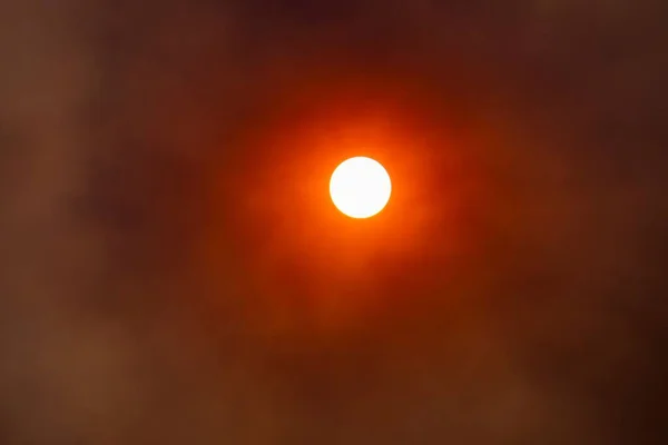 Vereinzelte Große Rote Sonne Durch Die Wolken — Stockfoto