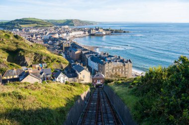A railroad taking to Aberystwyth town of Wales with a view of the sea clipart