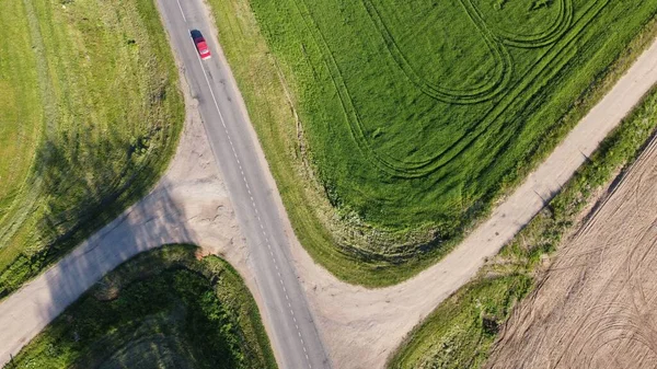 耕作された緑の畑を抜ける高速道路の空中ショット — ストック写真