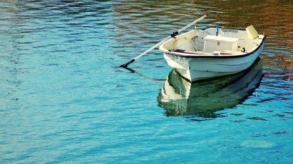 透明度の高い湖の水に浮かぶ白い小舟 — ストック写真