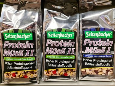 Süpermarketin rafında üç paket Seitenbacher marka protein müsli.