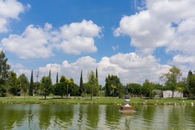 Güneşli bir günde, parkın yakınındaki gölette küçük bir heykelin güzel manzarası.